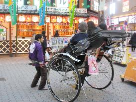 Tourists come to see Asakusa theaters in rickshaw