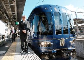 Industrial designer poses beside Kyoto railway train