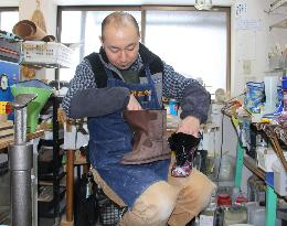 Shoemaker busy processing boots for people with leg problems