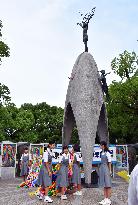 Students lay paper cranes at Children's Peace Monument in Hiroshima