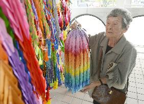 Woman in Nagasaki offers paper cranes for friends
