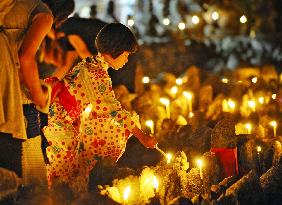 Girl lights up candle during annual service at Kyoto temple
