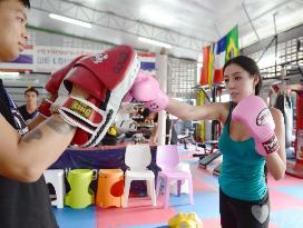 Weight-conscious Thai woman practices Muay Thai at Bangkok gym