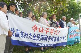 Okinawa plaintiffs hold banners in Naha
