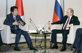 Abe, Putin agree to keep dialogue over islands, shelve Japan visit