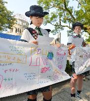 Children hold banners with peace messages in Hiroshima