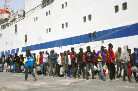 Immigrants board ferry for mainland on Lampedusa island