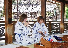 Visitors relax in room with reed screens at Dogo Onsen spa resort