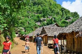 People walk along road at refugee camp in Thailand