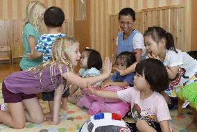 Young American girl plays with kids at nursery in Ishinomaki