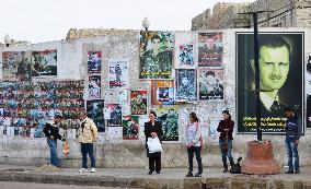 People wait for bus before photos of "martyrs" for Assad