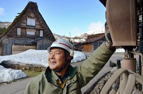 Man works to maintain power supply in snowy World Heritage village
