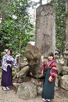 Storytellers point to stone turtle during "ghost tour" in west Japan