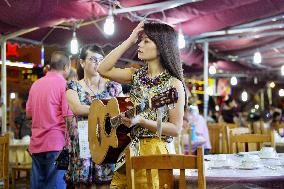 Chinese musician looks drowsy at Wuhan street stalls