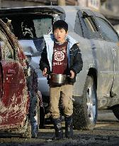 Boy carries meal at disaster area