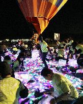 Paper strips with LED lights released from hot air balloon