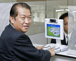 Justice minister tries out fingerprinting system at Narita