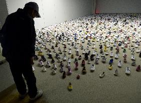 Artist displays 600 children's shoes on sand from disaster-hit Fukushima beach