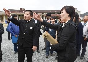 Premier's wife listens to tsunami survivor at school in north Japan