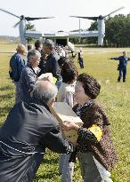 People carry relief goods from Osprey in disaster drill