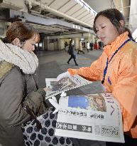 Newspaper staffer hands out extras in thanks for aid for 2011 quake