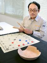 Drawing on ancient clay pot linked to paper board for traditional Korean game