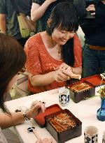 Woman sprinkles broiled eel with precious Japanese pepper in Kobe