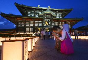 Woman bows before paper lanterns during "Obon" service at Todaiji