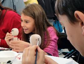 Expo Milano visitors enjoy painting dolls from Japan's Yamagata