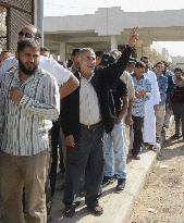 People wait in line to see Gaddafi's body