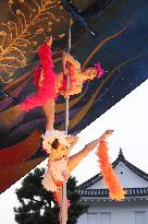 2 dancers perform pole dance in front of Nijo Castle