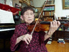 Aged woman plays violin to appeal for peace after WWII ordeal