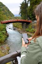 Spanish visitor uses smartphone to get info on Nikko tourist spots
