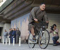 Sumo wrestler practices riding bike