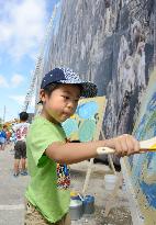 Boy experiences wall painting at construction site