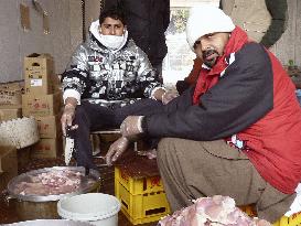 Muslim volunteers serve curry