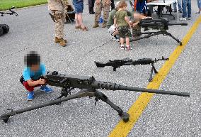 Kids touch machineguns at U.S. military fair in Okinawa