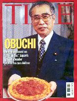 Obuchi holds a pizza on Time magazine cover, Kan mocks