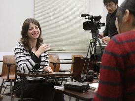 Syrian teacher smiles during video clip making in Japan