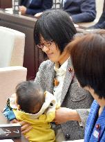 Assembly member brings baby to session