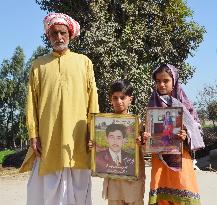 Orphaned Pakistan kids show photos of 'honor killing' victim parents