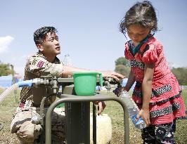 Gurkha soldier distributes water to quake victim in Kathmandu