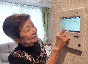 Woman operates intercom at senior residence in Yokohama