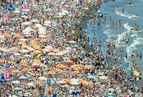 Beach crowded by a number of sea bathers, swimmers