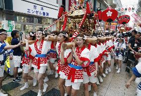 Young women carry "mikoshi"
