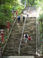 Mountain climbers go up stone steps on Mt. Takao in Tokyo suburb
