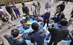 Homeless people pick clothes supplied by support group in Sendai