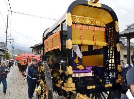 Ancient court carriage parades on approach to temple in western Japan