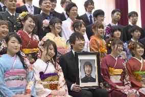 Photo of disaster victim among new adults at ceremony