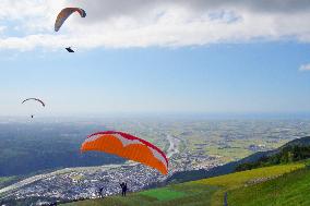 Paragliders fly over highland in central Japan